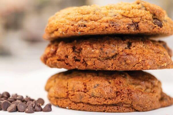 Three chocolate chip cookies stacked high.